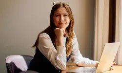 Kvinde arbejder på laptop ved skrivebord i moderne kontormiljø